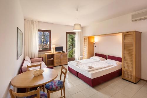 1 dormitorio con cama, mesa y escritorio en Residence il Cedro, en Malcesine