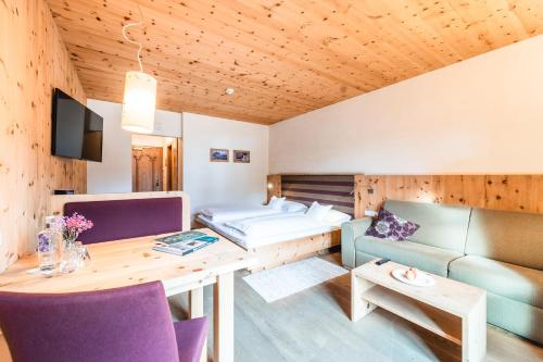 a living room with a table and a couch at Naturhotel Leitlhof in San Candido