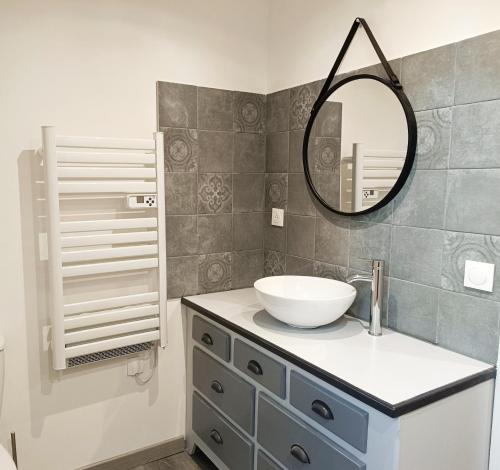 une salle de bain avec un lavabo et un miroir dans l'établissement Normandie entre campagne et mer, à Émiéville