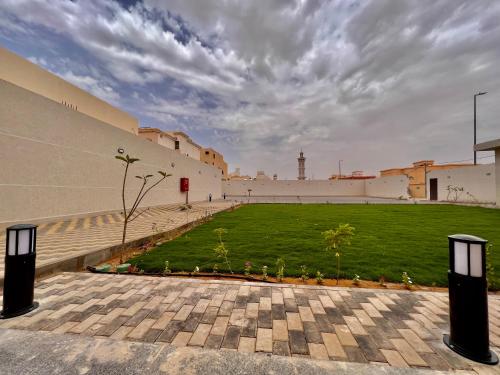a building with a grassy courtyard with a building at مارينا نجد للشقق الفندقية in Hotat bani tamim