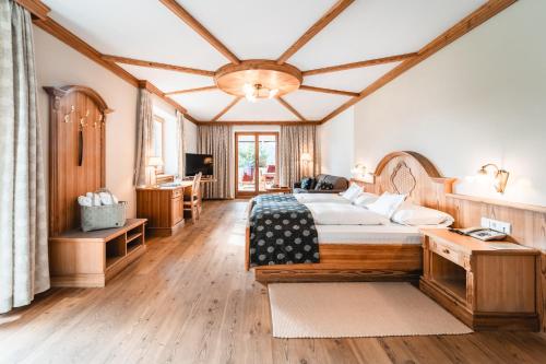 Großes Zimmer mit einem Bett und einem Tisch in der Unterkunft Naturhotel Leitlhof in Innichen
