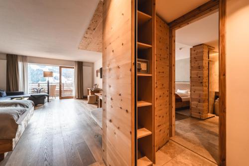 ein Schlafzimmer mit einer Schiebetür zu einem Zimmer in der Unterkunft Naturhotel Leitlhof in Innichen