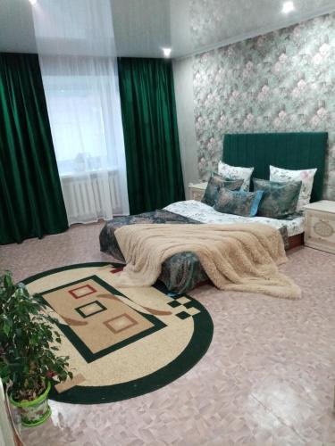 ein Schlafzimmer mit einem Bett und einem Teppich auf dem Boden in der Unterkunft Всегда рады гостям центр города in Oral