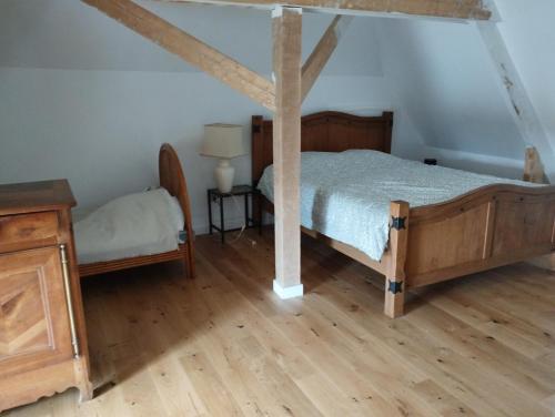 une chambre avec un lit et un parquet dans l'établissement Petite chambre - Maison de Maître, à Landéan