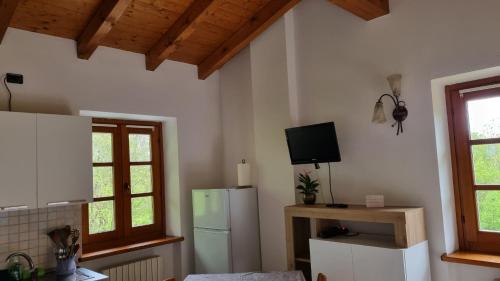 eine Küche mit einem Kühlschrank und einem TV an der Wand in der Unterkunft Agriturismo Pastorelli in Osmate Lentate
