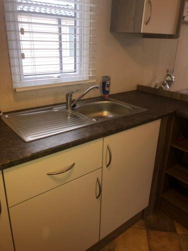 um balcão de cozinha com um lavatório e uma janela em Blue quary em Hastings