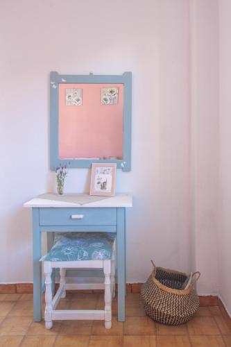 a blue desk with a mirror and a basket at Passiflora Vacation House in Nydri