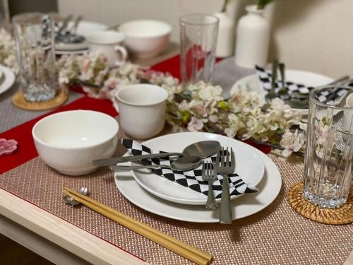 a table with a plate and utensils on a table at 日本の一軒家貸切 Goodfellas Inn Osaka 鶴橋1 in Osaka