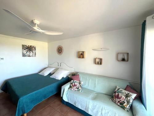 ein Hotelzimmer mit einem Bett und einem Sofa in der Unterkunft Studio Ti Karanbol RDC vue mer dans Résidence de Tourisme in Sainte-Anne