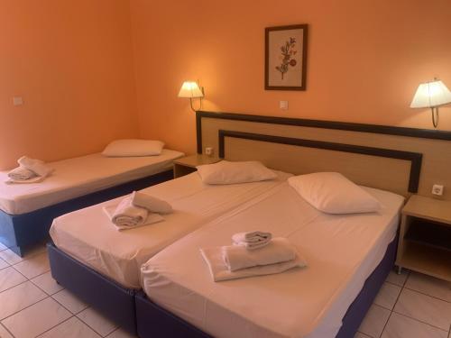 two beds in a hotel room with towels on them at Polychrono Beach Hotel in Polykhrono
