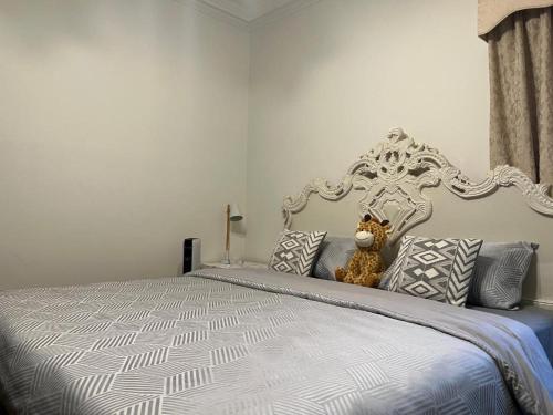 a teddy bear sitting on a bed with pillows at Pleasant Private Room in Taylors Lake Near Melbourne Airport in Taylors Lakes