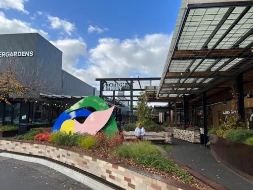 a person sitting on a bench in front of a building at Pleasant Private Room in Taylors Lake Near Melbourne Airport in Taylors Lakes