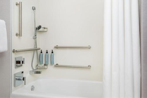 a bathroom with a bath tub with a shower curtain at Courtyard by Marriott Minneapolis-St. Paul Airport in Mendota Heights