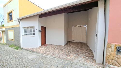 eine offene Tür eines Hauses mit Auffahrt in der Unterkunft Morada dos Anjos in Aparecida