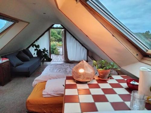 a attic bedroom with a checkered floor at Tuinkamer in charmante smidse in Zwalm