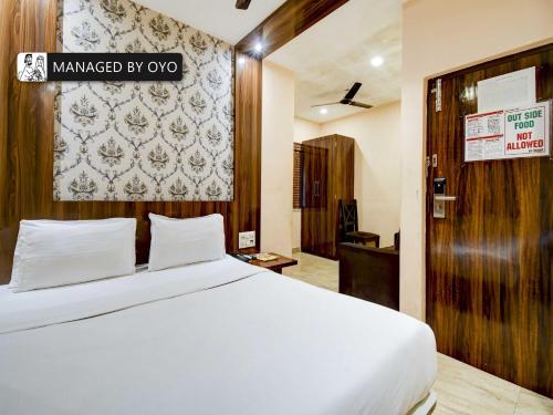a bedroom with a white bed with a sign on the wall at Townhouse Imperio Ballygunge Near Park Circus in Ballygunge