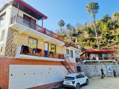 a house with a car parked in front of it at Exclusive Nagar Cottage in Mukteshwar