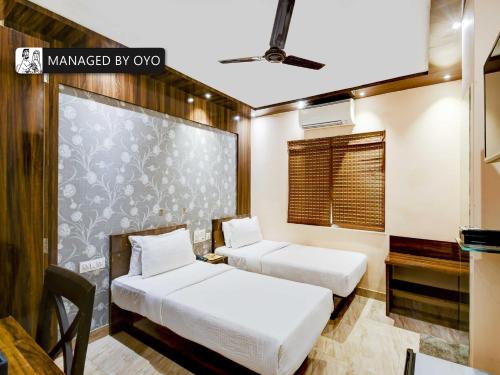 two beds in a room with a wall with a window at Townhouse Ballygunge Near Quest Mall in Ballygunge