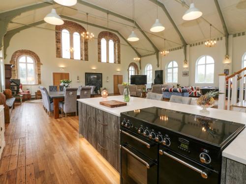 an open kitchen and living room with a stove at The Miners Hall Retreat in Stanley