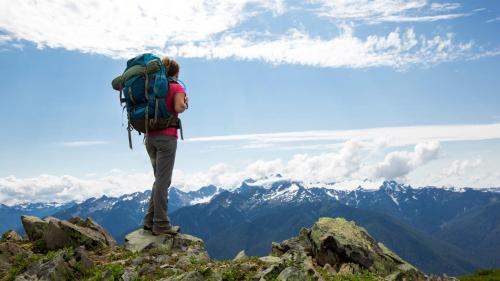 a person with a backpack standing on top of a mountain at Cozy Mountain Apartment in Borovets