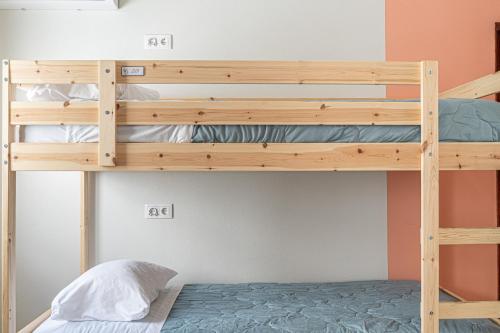 a bunk bed in a small room with a bunk bed in a bedroom at Sandy Bottoms Hostel in Albufeira