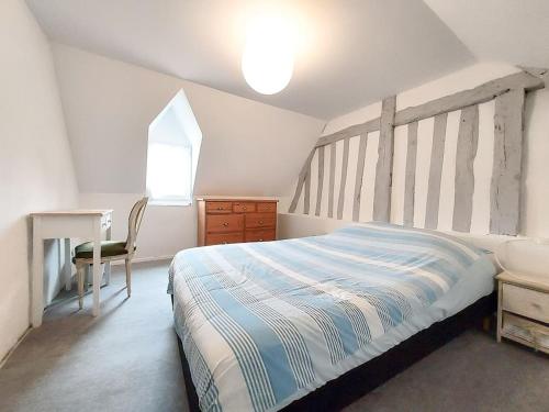 Schlafzimmer mit einem Bett, einem Schreibtisch und einem Fenster in der Unterkunft Maison de charme - Piscine chauffée - 8 personnes in Danestal