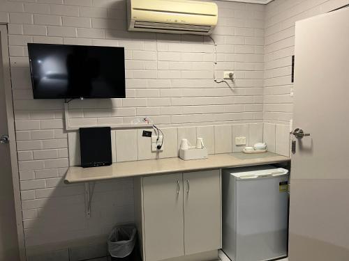 a bathroom with a counter with a tv on the wall at Bairnsdale Town Central Motel in Bairnsdale