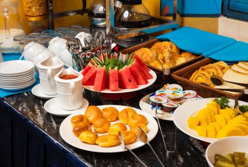 a buffet with plates of food on a table at Casa Valentina Hanoi Hotel in Hanoi