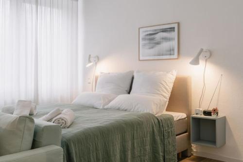 a bedroom with a bed with white sheets and pillows at Central Apartment near Opera - 1 Room in Bayreuth