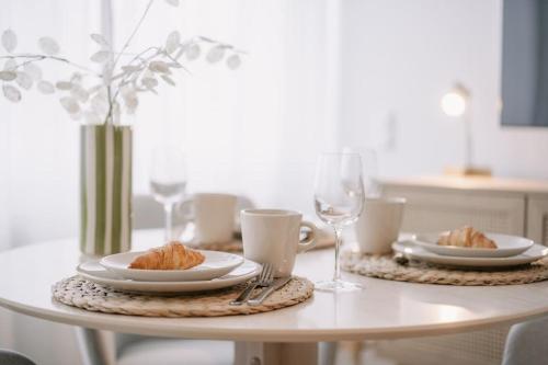a white table with plates of food and wine glasses at Central Apartment near Opera - 1 Room in Bayreuth