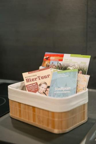 a container filled with books and magazines on a table at Central Apartment near Opera - 1 Room in Bayreuth