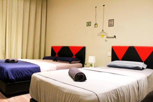 2 Betten in einem Zimmer mit rot und schwarz in der Unterkunft Riverson SOHO Kota Kinabalu in Kota Kinabalu