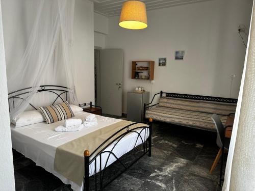 1 dormitorio con cama y banco. en KIRIKOS ROOMS, en Sifnos