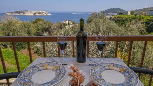 a table with two plates and a bottle of wine at Mimas Home in Hisarcık