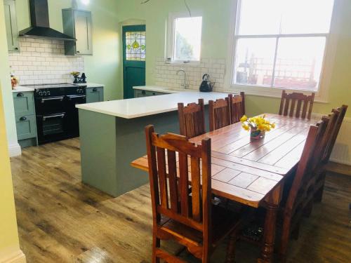 a kitchen with a wooden table with chairs and a kitchen island at Llangollen Townhouse 4 bedroom in Llangollen