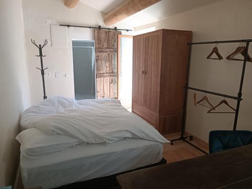 ein Schlafzimmer mit einem weißen Bett und einem Schrank in der Unterkunft Lou Boulugi in Aix-en-Provence