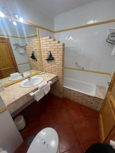 a bathroom with a sink and a tub and a toilet at Hotel Gavitu in Celorio