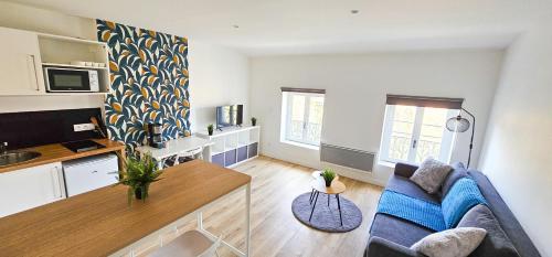 un salon avec un canapé bleu et une cuisine dans l'établissement Le Chavanelle!, à Saint-Étienne