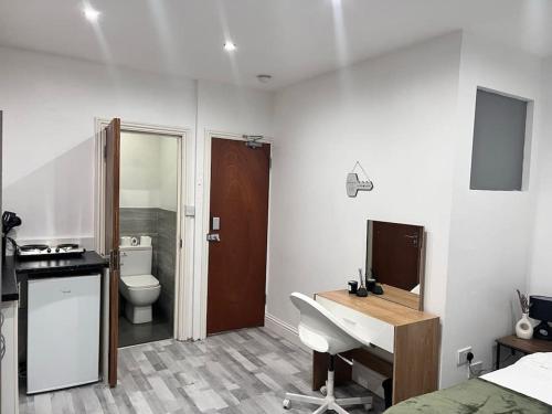 een badkamer met een wastafel, een toilet en een bureau bij Deluxe Size - Entire Studio in Seven Kings