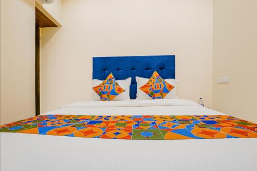 um quarto com uma cama com um edredão colorido em FabExpress Kurla Inn em Mumbai