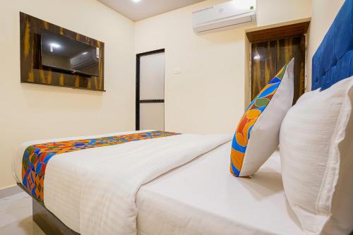 a bedroom with a bed with a surfboard on it at FabExpress Kurla Inn - Nr BKC in Mumbai