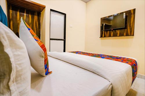 a bedroom with a bed and a tv on the wall at FabExpress Kurla Inn - Nr BKC in Mumbai