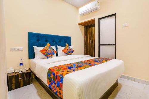 a bedroom with a large bed with a colorful blanket at FabExpress Kurla Inn - Nr BKC in Mumbai