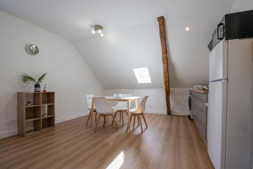 a kitchen with a table and chairs and a refrigerator at Bellerivois - 5 min des rives in Bellerive-sur-Allier