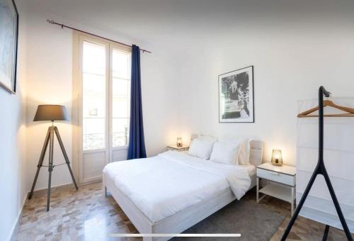 une chambre avec un lit blanc et une grande fenêtre dans l'établissement Monte Carlo Monaco border, hypercenter, familly friendly, à Beausoleil