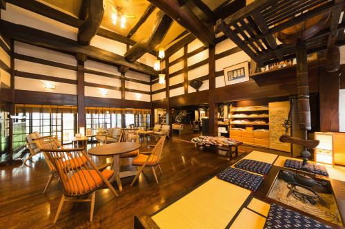 a large room with tables and chairs and a stove at Ryokan Asunaro in Takayama