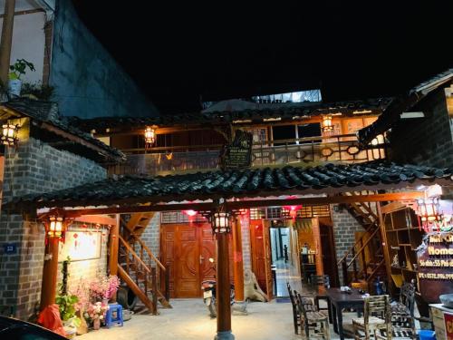 a building with a patio with a table and chairs at Mai's Homestay Dong Van in Dồng Văn