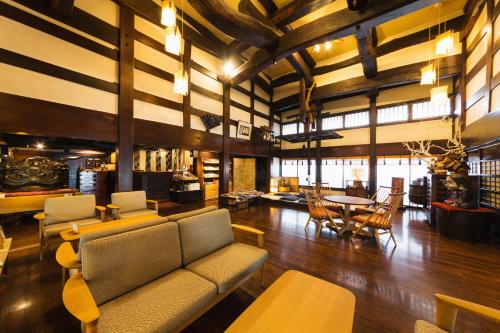 a living room with a couch and a table and chairs at Ryokan Asunaro in Takayama