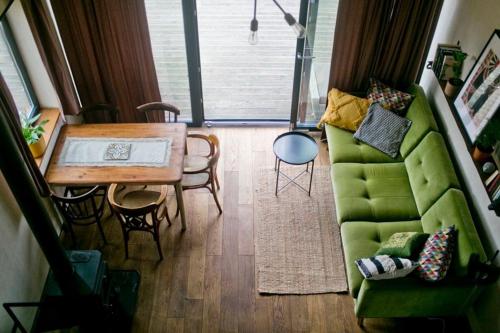 ein Wohnzimmer mit einem grünen Sofa und einem Tisch in der Unterkunft Powoli - wyjątkowy domek w Izerach in Wolimierz