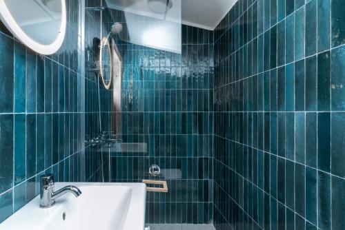 a bathroom with green tiled walls and a sink at Bel Assis in Ulcinj